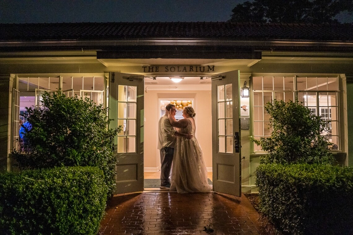 A night time reception photo of the couple in front of the Solarium at Historic Scottish Rite wedding venue in Decatur