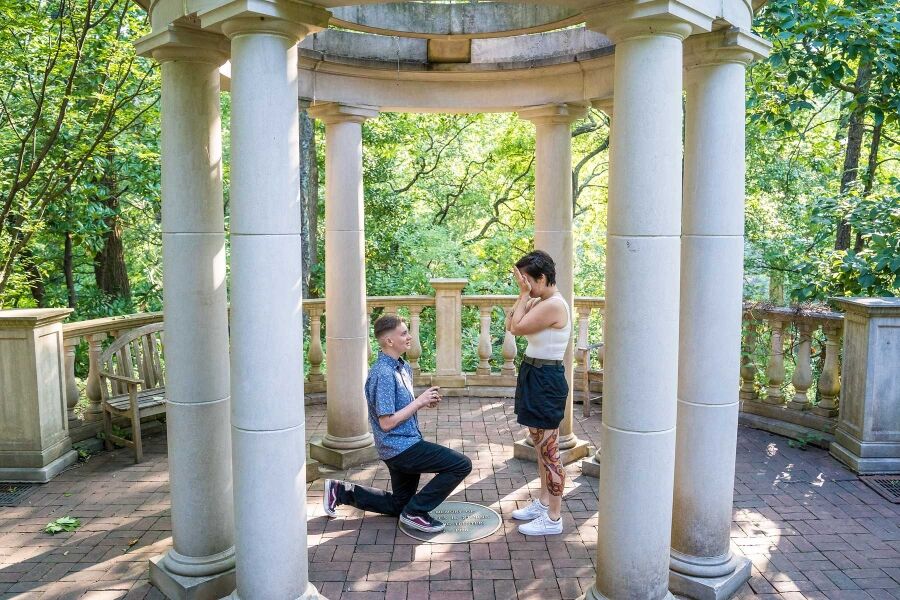 Surprise proposal on one knee inside the white stone gazebo at the Atlanta Botanical Garden