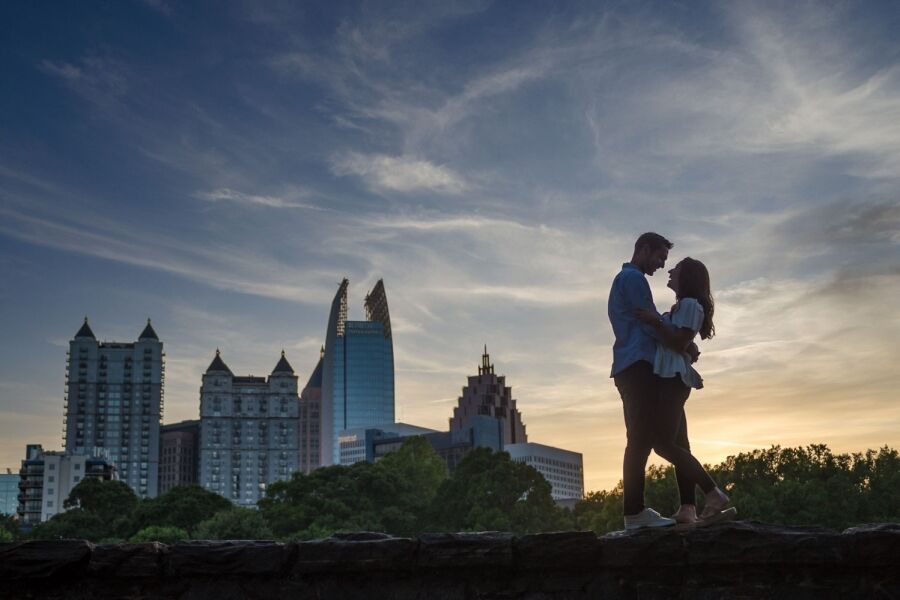 Engaged couple silhouetted against the Midtown Atlanta skyline at sunset